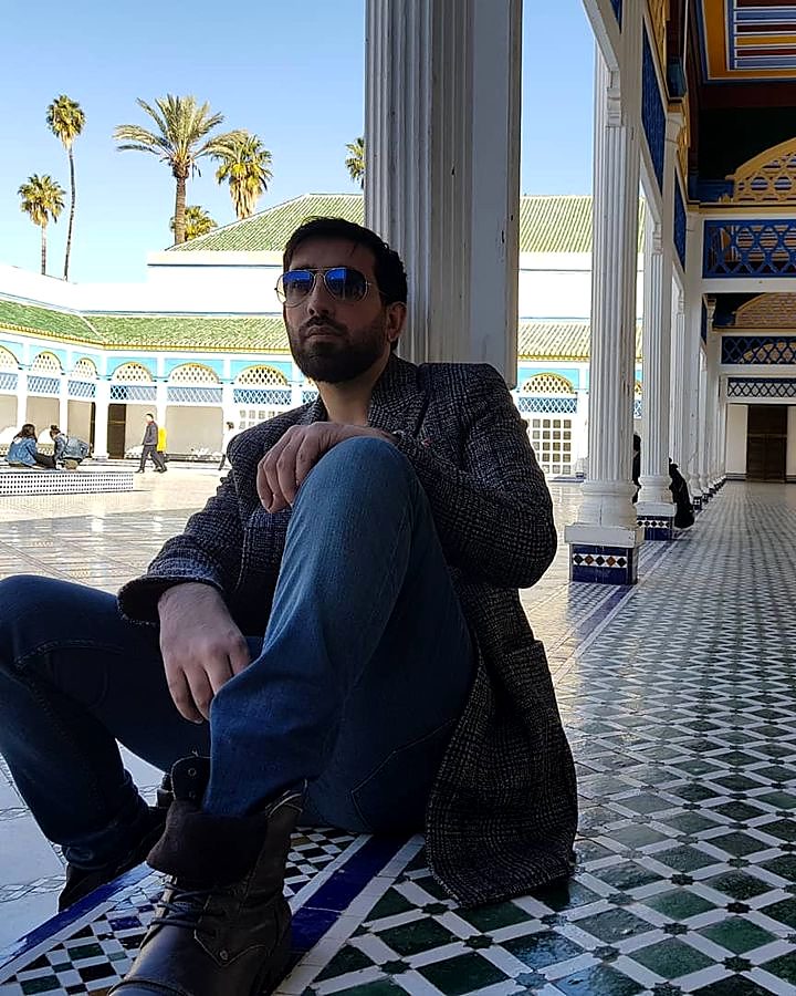 Kaiser Khan seated in a tiled palace courtyard in Morocco